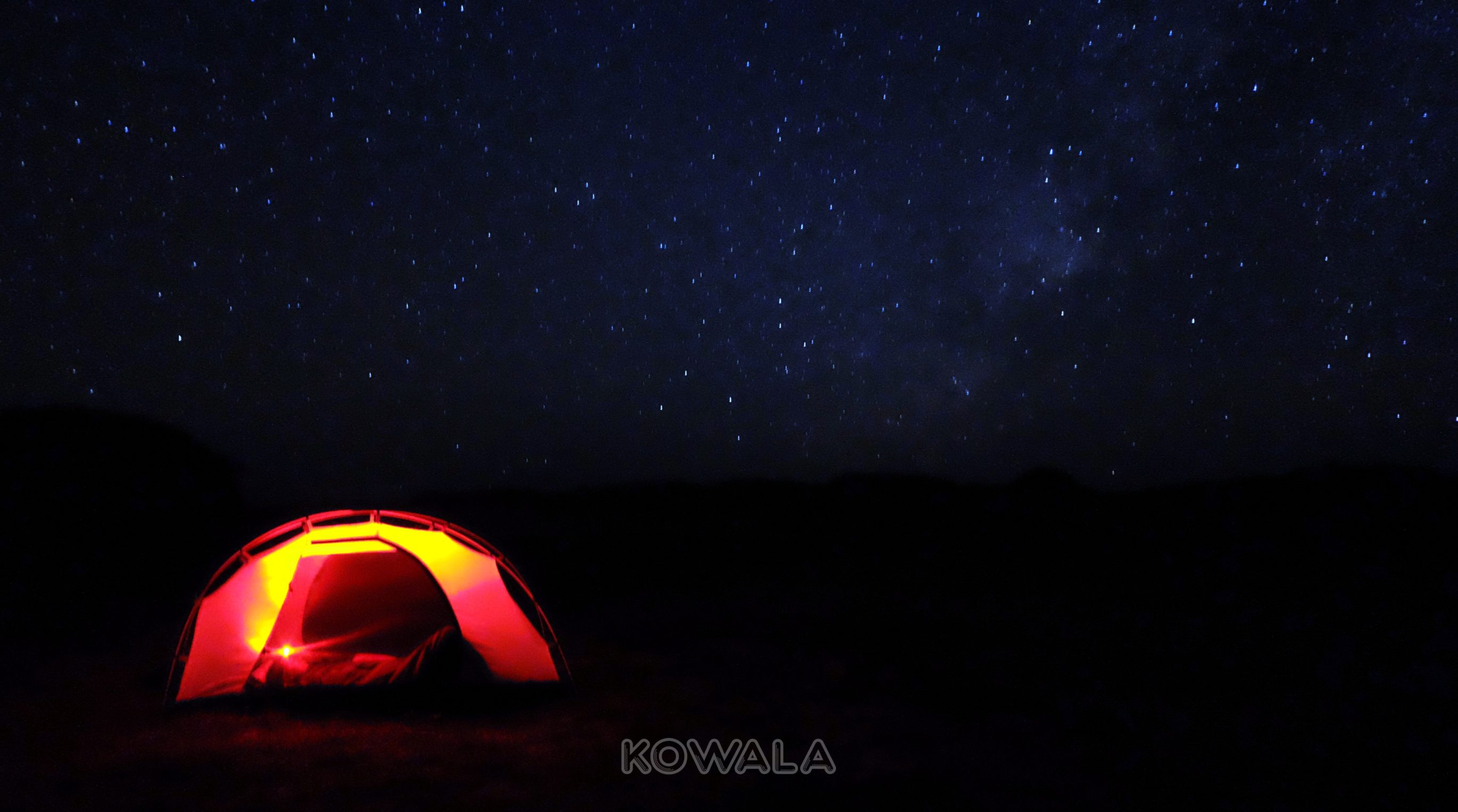 Un campement en bord de plage sous les étoiles.